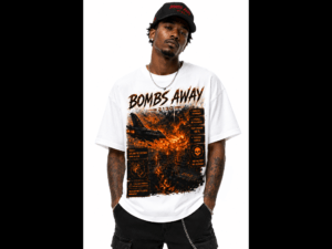Man wearing a black cap and a large white T‑shirt with fiery orange graphics and text, facing forward.