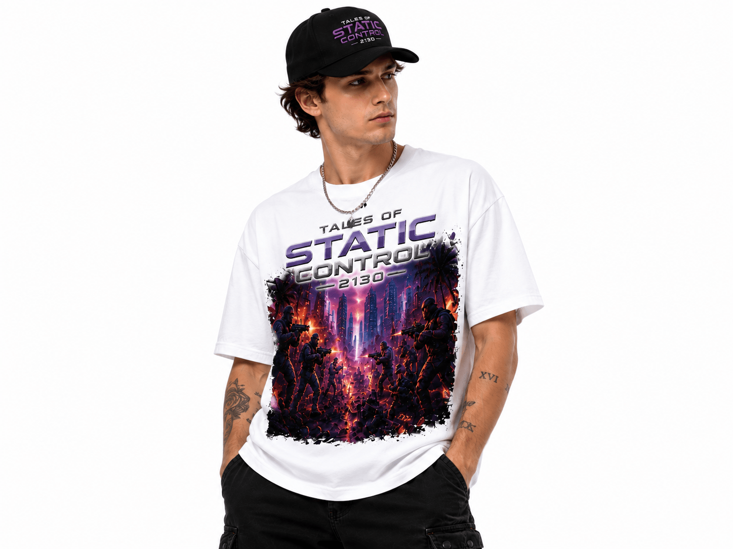 Man wearing a white graphic T-shirt with a neon purple cityscape battle design and the text 'Tales of Static Control' with a black cap on.